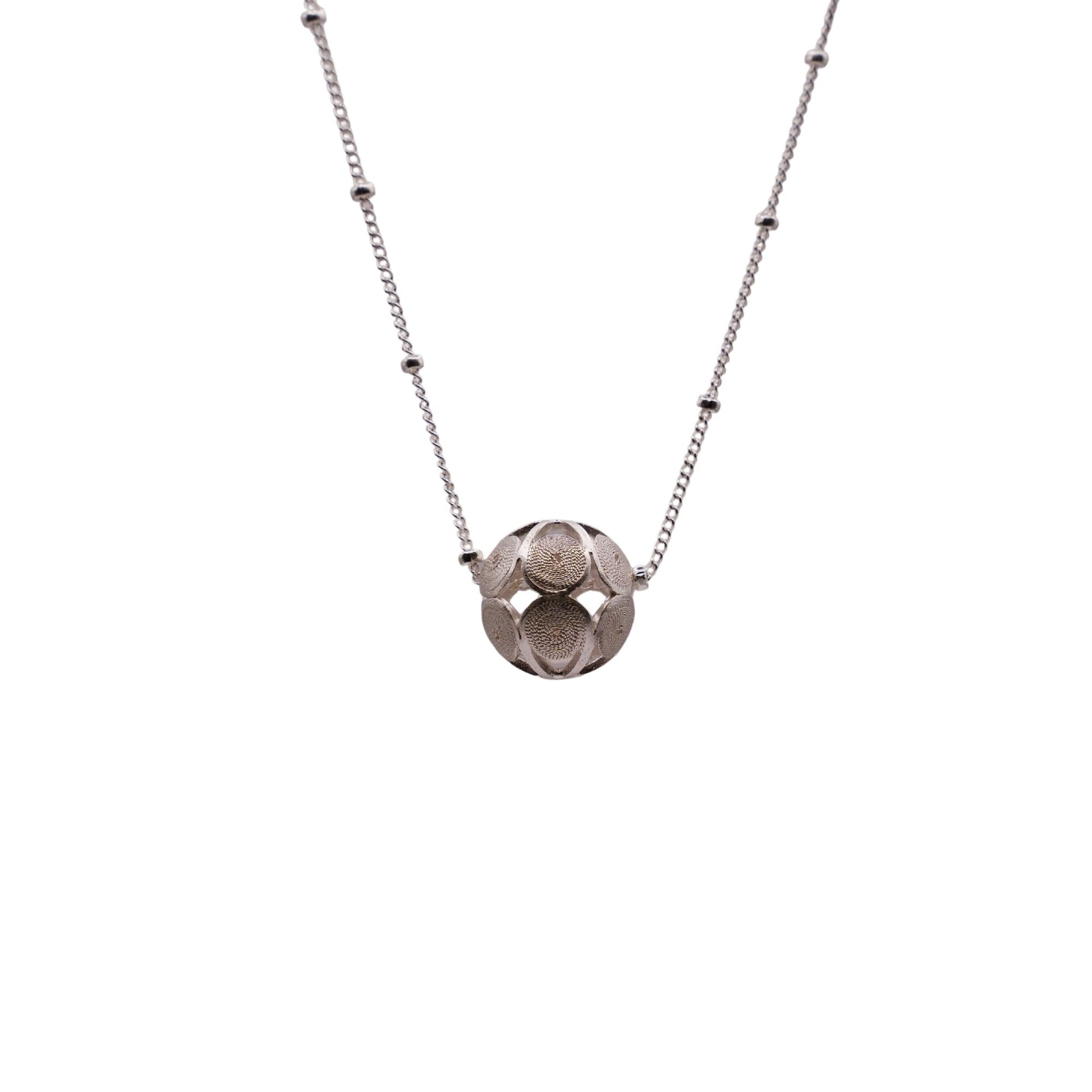 Silver necklace with a geometric pendant on a white background