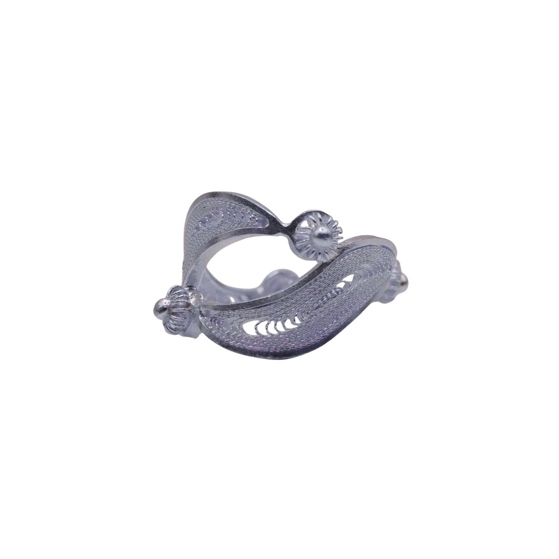 Silver ear cuff with intricate design on a white background