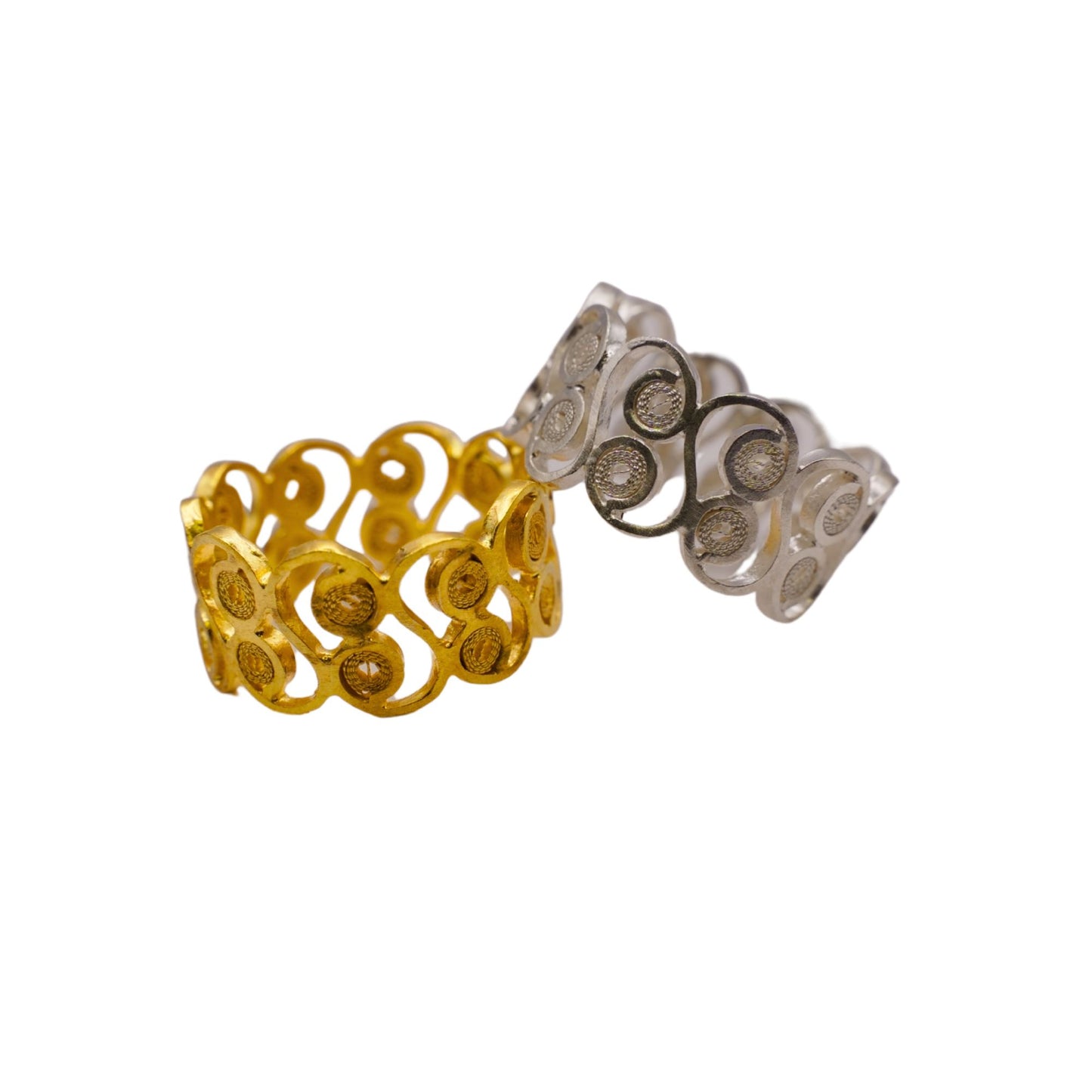 Gold and silver rings with intricate designs on a white background